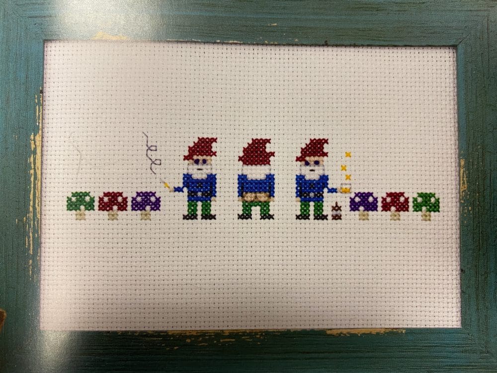 A cross stitch pattern project of three gnomes