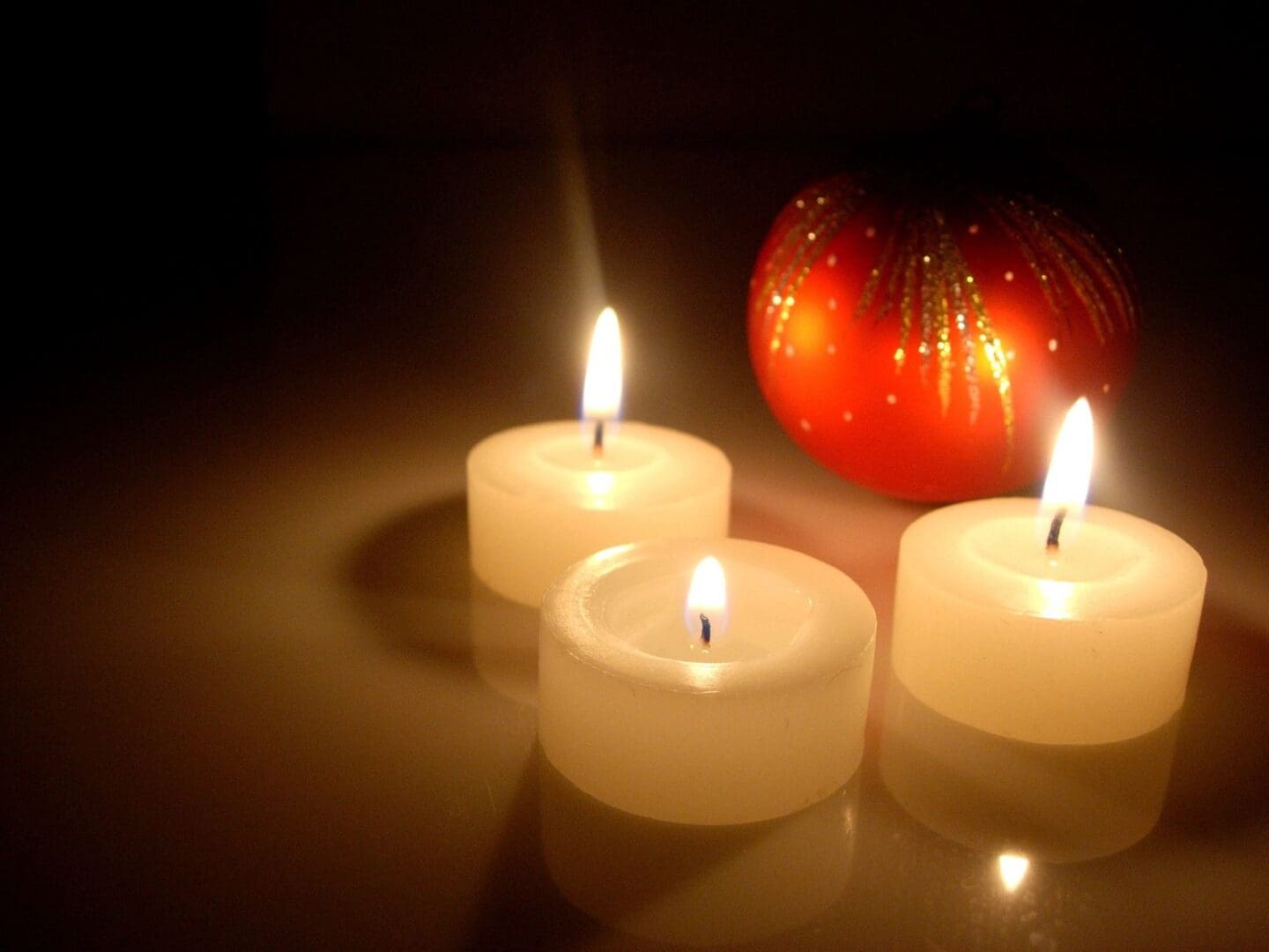 Three Burning White Candles in Dark