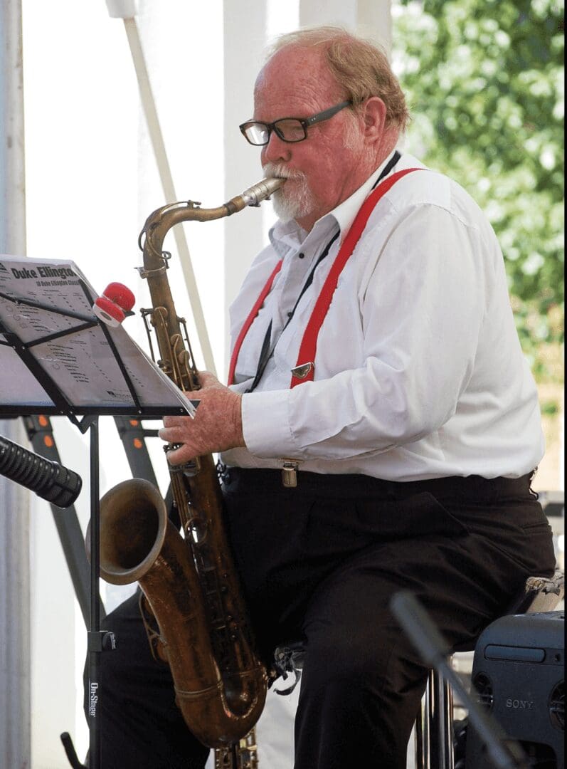 A Man in a White Shirt Playing a Saxophone