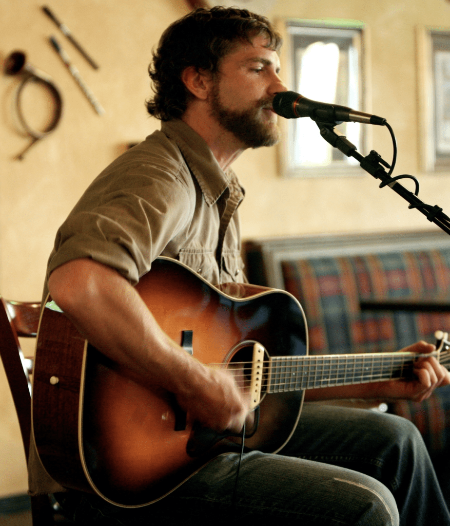 A man playing an acoustic guitar.