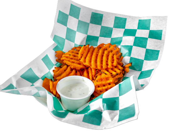 A basket of sweet potato fries with dipping sauce.