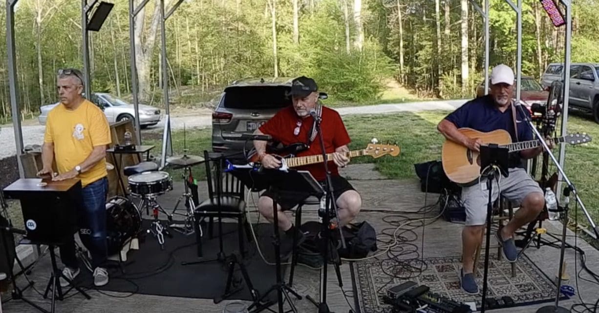 A group of people playing music on a porch.