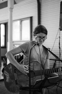 Image may contain person, playing a musical instrument, on stage and guitar.