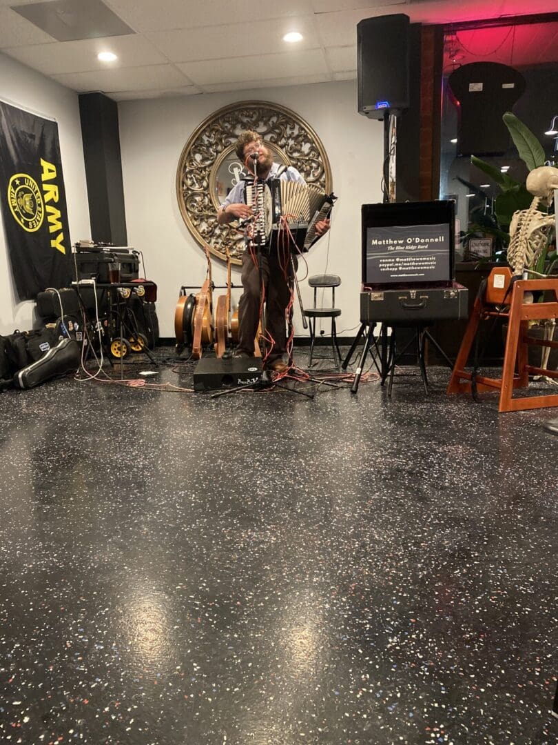 A man playing music on a stage in a room.